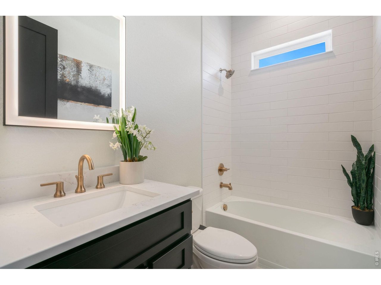 Main Floor Full Bath includes backlit mirror and champaign bronze fixtures