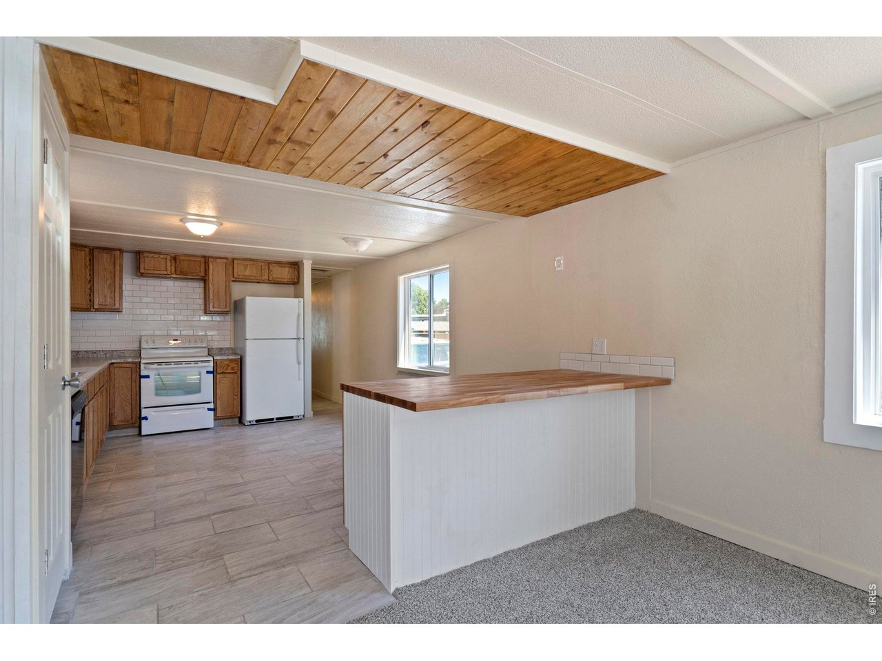 Step inside to find a great open concept layout. Knotty pine accented ceiling, with a bar between living room and kitchen. Butcher block top. 