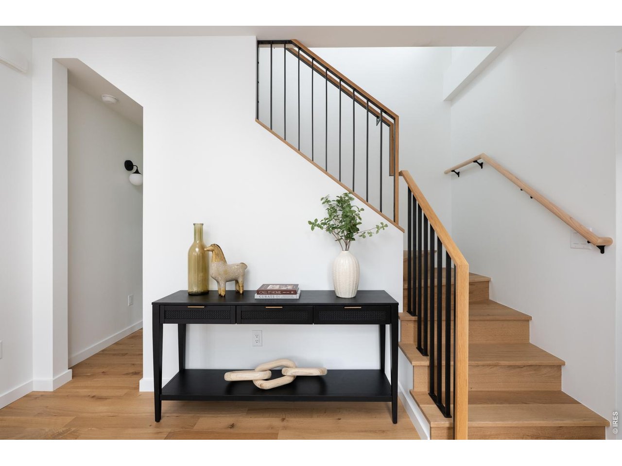 Oak banister leads to upper level primary suite and guest suite. 