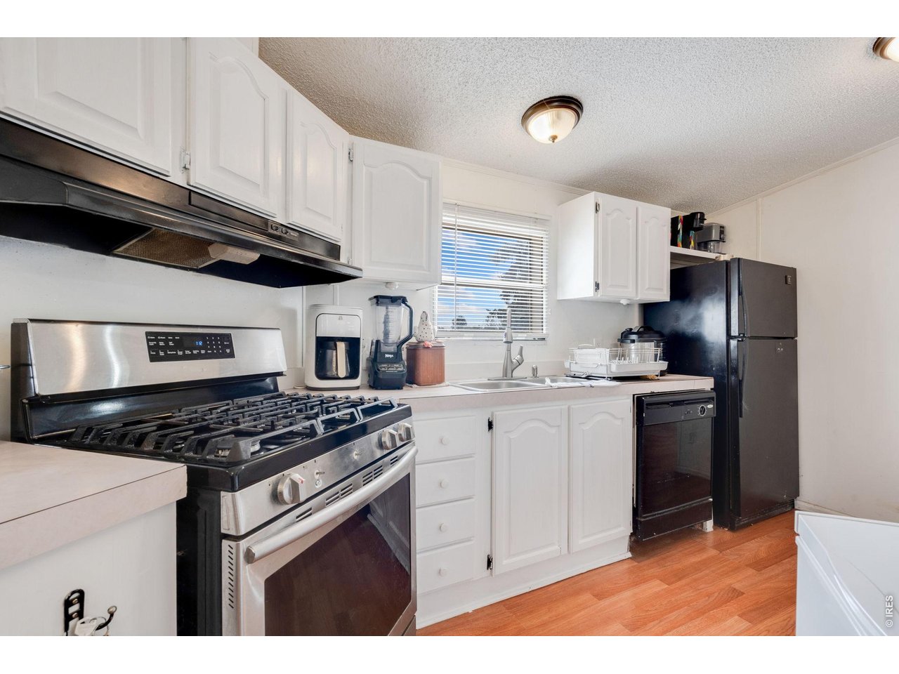 Beautiful freshly painted white cabinets. Stainless steel gas stove/range.