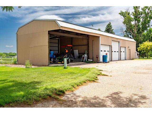 Property Photo 17 Includes a three-stall outbuilding with garage doors. 