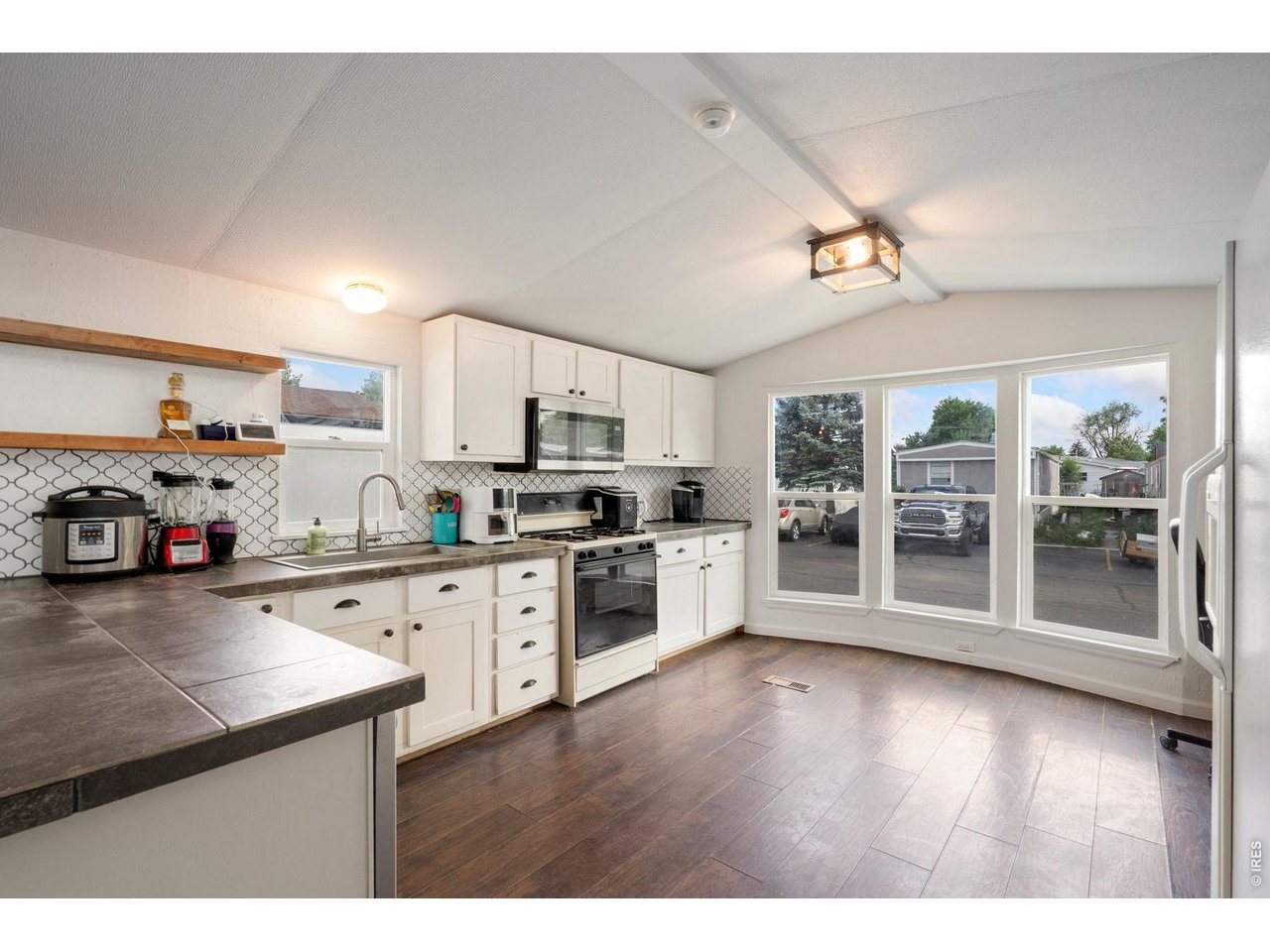 Kitchen with large windows allowing ample light into home.