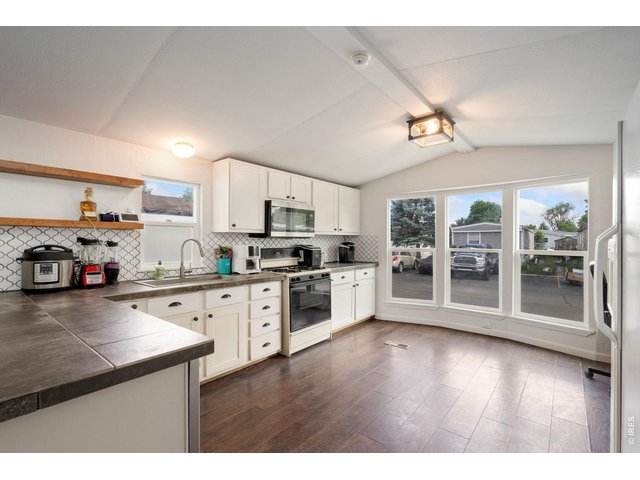 Property Photo 6 Kitchen with large windows allowing ample light into home.