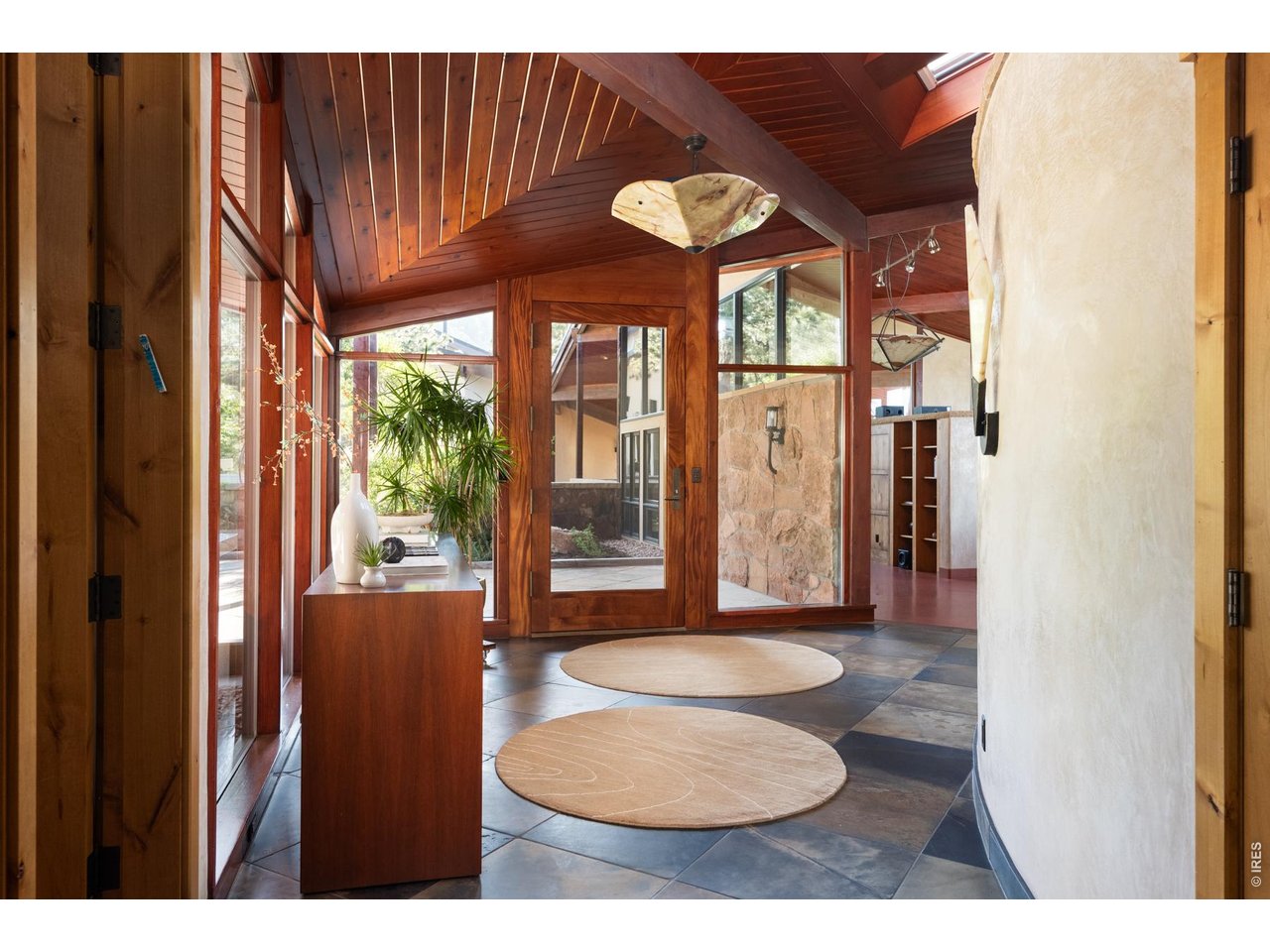 Enter the home through an African mahogany grand front door. Greeted by slate flooring and cementitious curved Venetian plaster walls. 