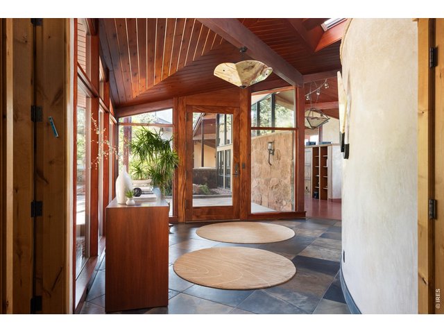 Property Photo 10 Enter the home through an African mahogany grand front door. Greeted by slate flooring and cementitious curved Venetian plaster walls. 