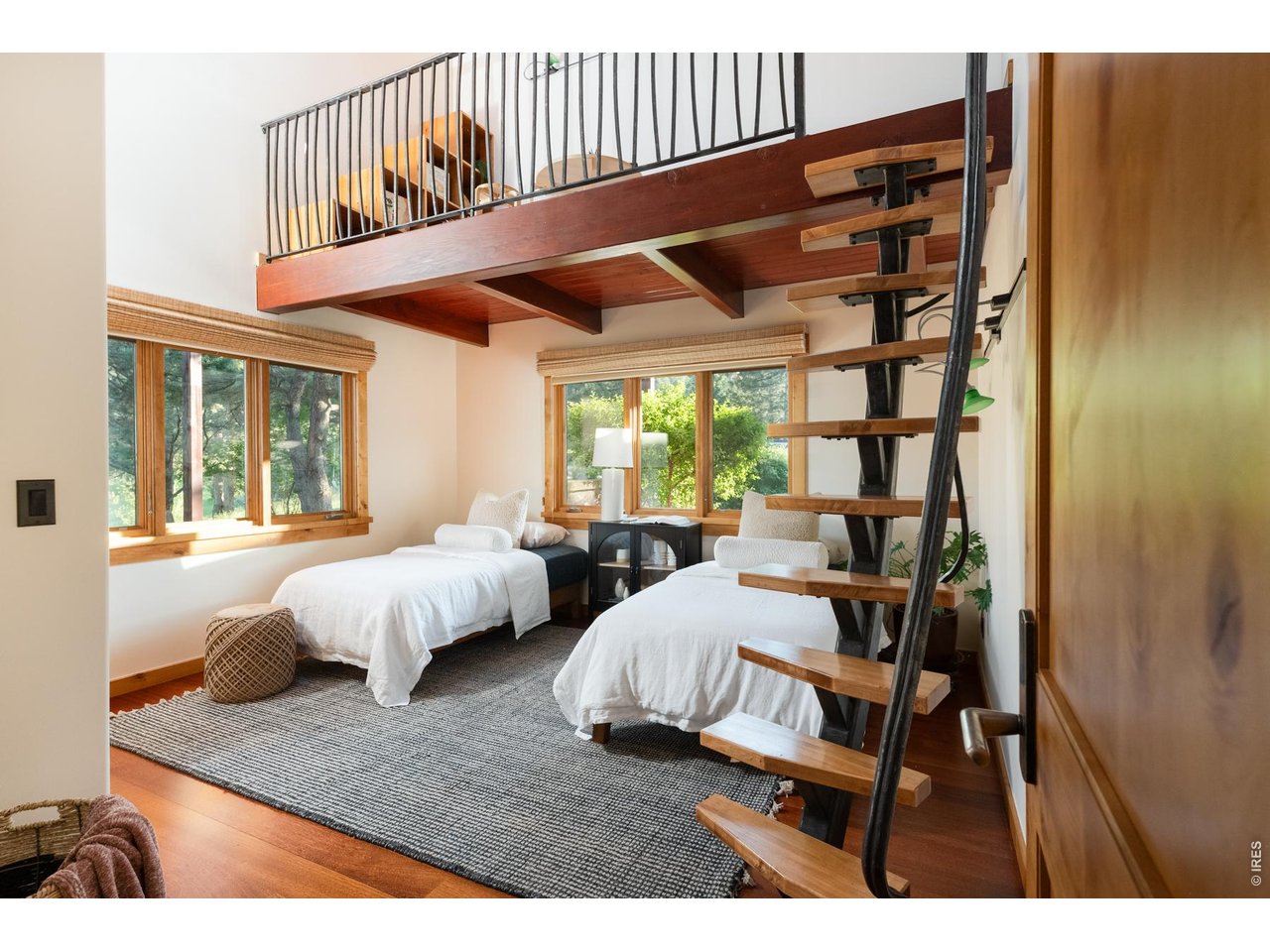 Main level guest bedroom featuring Brazilian Cherry (Jatoba) hardwood floor and a forged iron ladder leading to a lofted reading/play space.