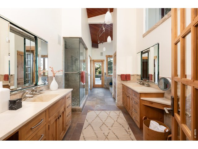 Property Photo 22 Luxury primary suite bath with his & hers vanities, soaking tub and limestone counters. Including a water closet with toilet and bidet, steam shower with rain head, hand shower, Dolomite stone and river rock floor. 