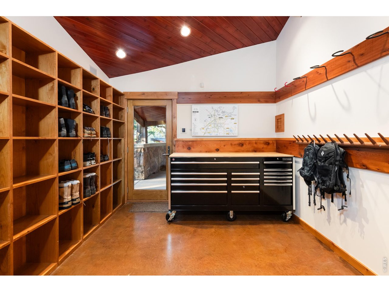 Mudroom and bike workshop space with heated floors and stairs leading to guest room. 