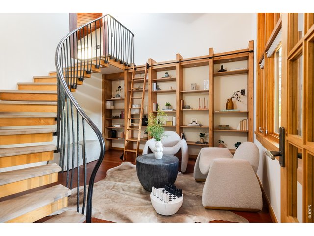 Property Photo 26 Main level library with wall of custom built-in shelves with rolling ladder. 