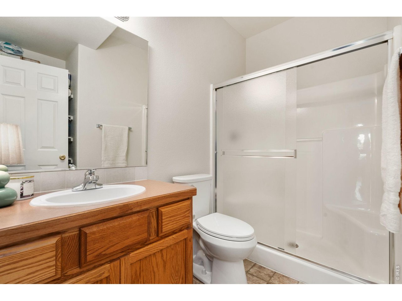 Guest bath is clean and convenient right off the hallway, with storage space behind the door.