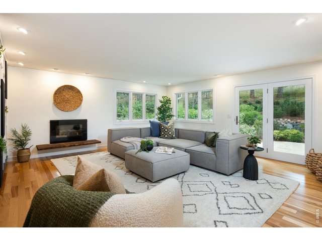 Property Photo 10 Relax in the corner living room surrounded by a fireplace, built-ins and verdant views.