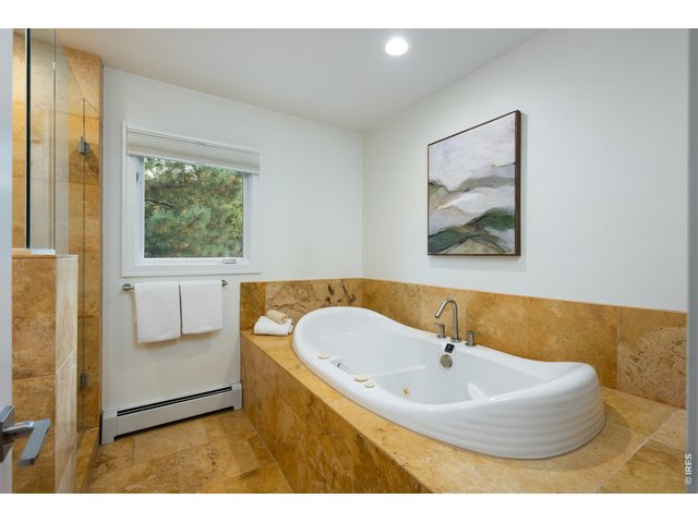 Property Photo 30 The windowed en suite spa bath boasts a freestanding soaking tub, shower & partially private toilet.