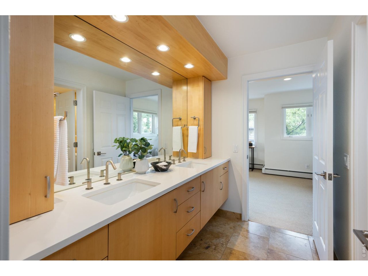 Luxurious primary bath with oversized double sink vanity, radiant in-floor heating and custom cabinetry. 