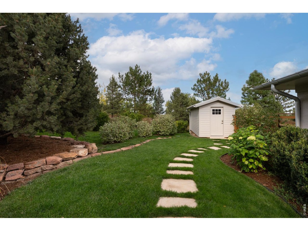 The spacious garden shed adds additional storage and organization. 