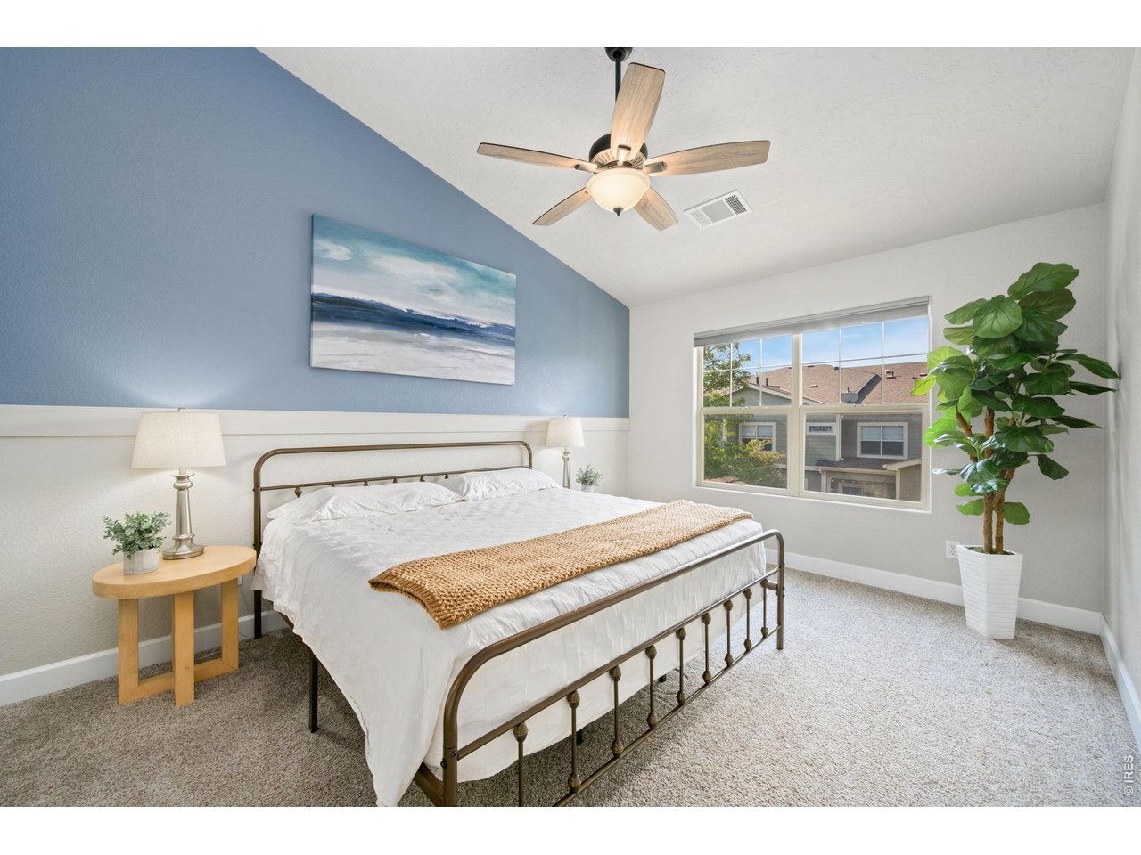Primary bedroom with vaulted ceilings and abundant light.