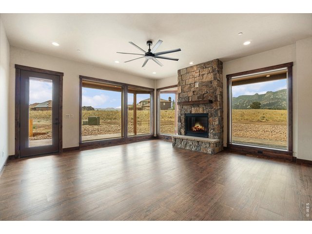 Property Photo 4 Oversized picture windows frame the stone gas fireplace