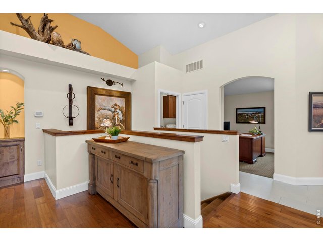 Property Photo 20 Living view into the front office, open stairway to lower level and hallway to Primary Bedroom