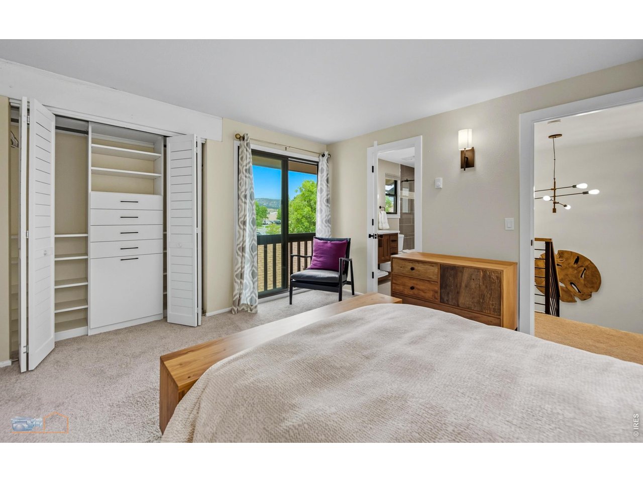 Primary bedroom with custom California closet system & views of the Flatirons. 