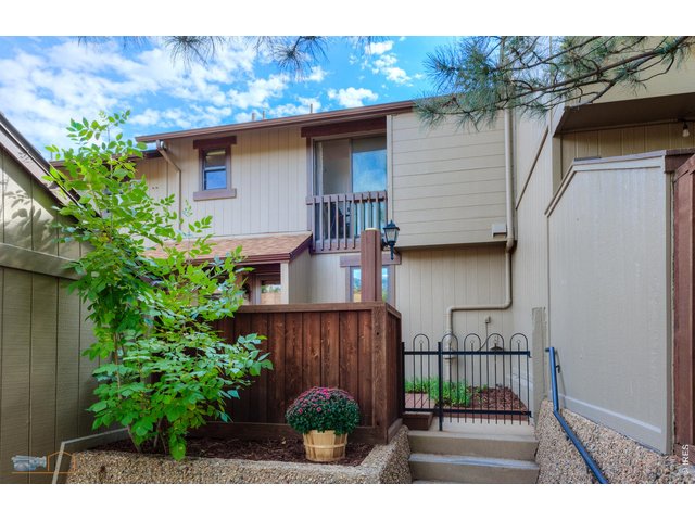 Property Photo 1 Front of the townhome with gardens and a large private deck.
