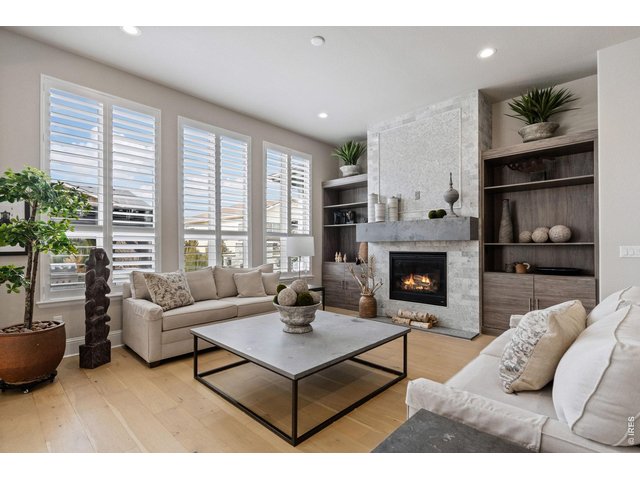 Property Photo 8 Inside, soaring vaulted ceilings and expansive windows bathe the interiors in natural light, highlighting wide-plank engineered hardwood floors and impeccable craftsmanship throughout.