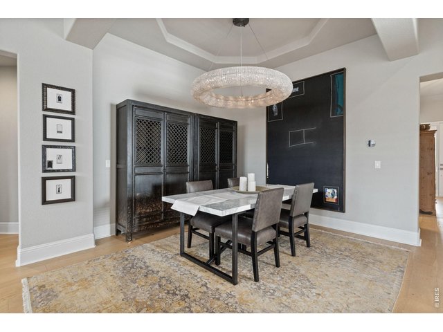 Property Photo 20 An elegant dining space, crowned by a striking crystal chandelier, offers the perfect setting for intimate dinners or celebratory evenings with friends.