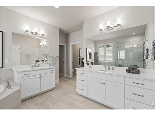 Property Photo 26 A spa-inspired five-piece bath features a soaking tub, walk-in shower, dual vanities, and a beautifully customized walk-in closet.