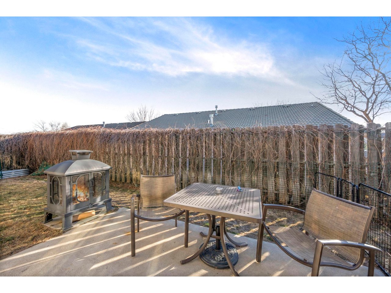 Fully enclosed back yard, with patio and raised garden beds.