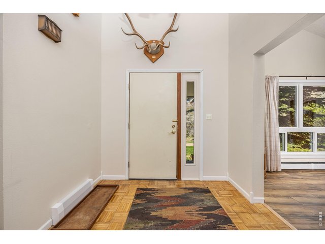 Property Photo 8 Inside, enjoy an open, light-filled layout with vaulted ceilings, large windows, and a cozy wood-burning fireplace. 