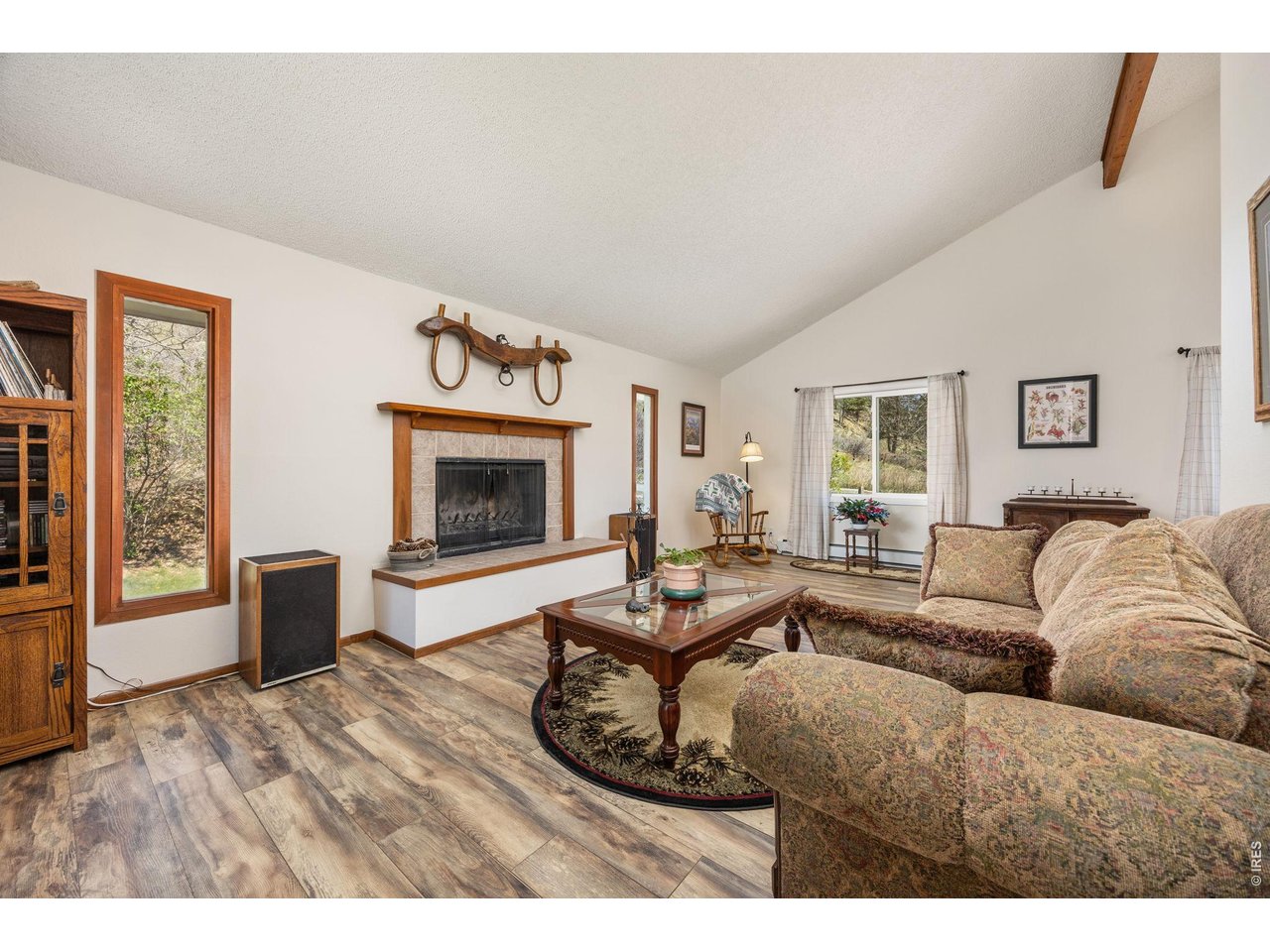  Inside, enjoy an open, light-filled layout with vaulted ceilings, large windows, and a cozy wood-burning fireplace.