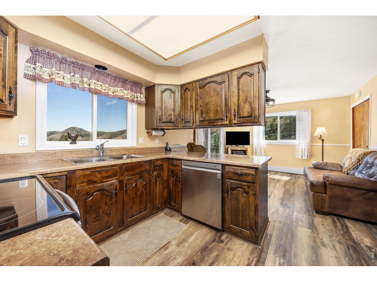 The kitchen features generous cabinet and counter space, stainless steel electric range and microwave, and all appliances are in excellent condition.