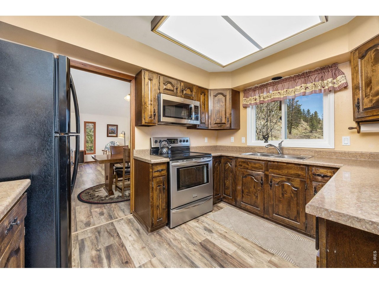 The kitchen features generous cabinet and counter space, stainless steel electric range and microwave, and all appliances are in excellent condition.