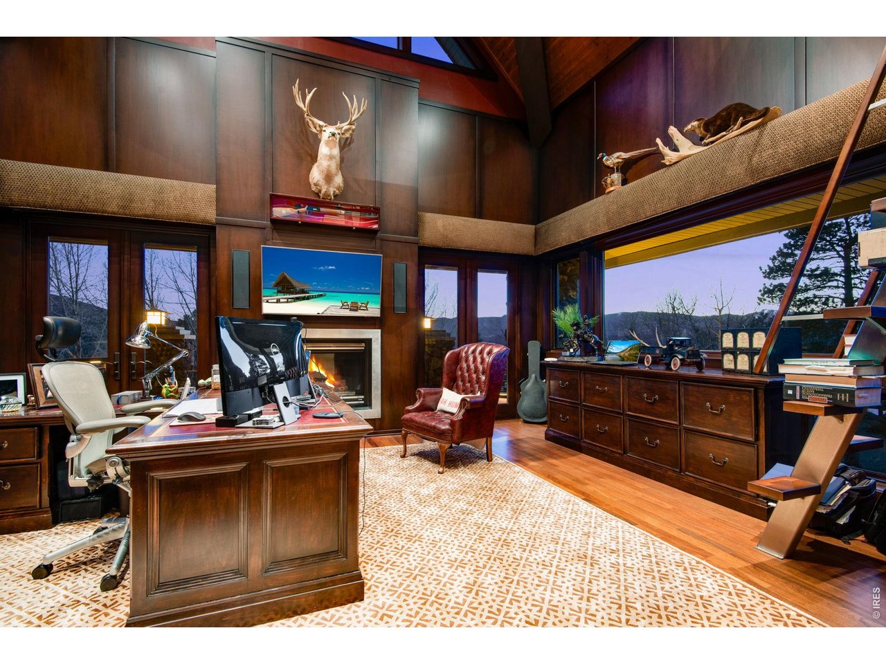 There are two executive office suites. This office suite, tucked away from the rest of the home, has panoramic mountain views. The ladder leads to a balcony above.