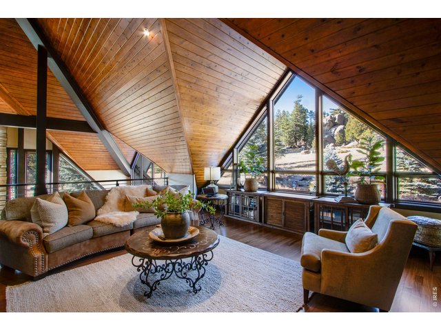 Property Photo 36 Sitting area/loft above the main floor. Triangular shapes and exotic materials are found on every surface of the home. The ceiling of this room is stunning! As is the forest outside the window!