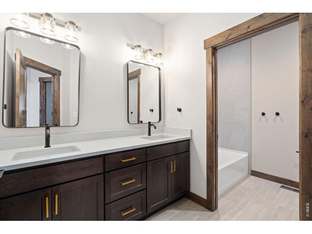 Property Photo 26 Upstairs bathroom with quartz countertops, double sinks, and tub/shower