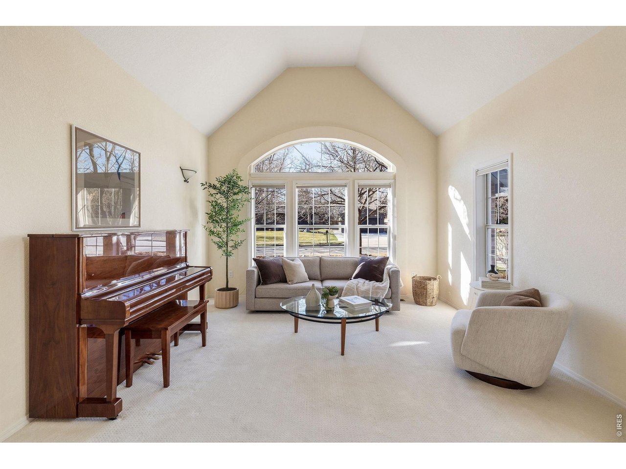 Elegant, sunken living room with vaulted ceiling and oversized windows.