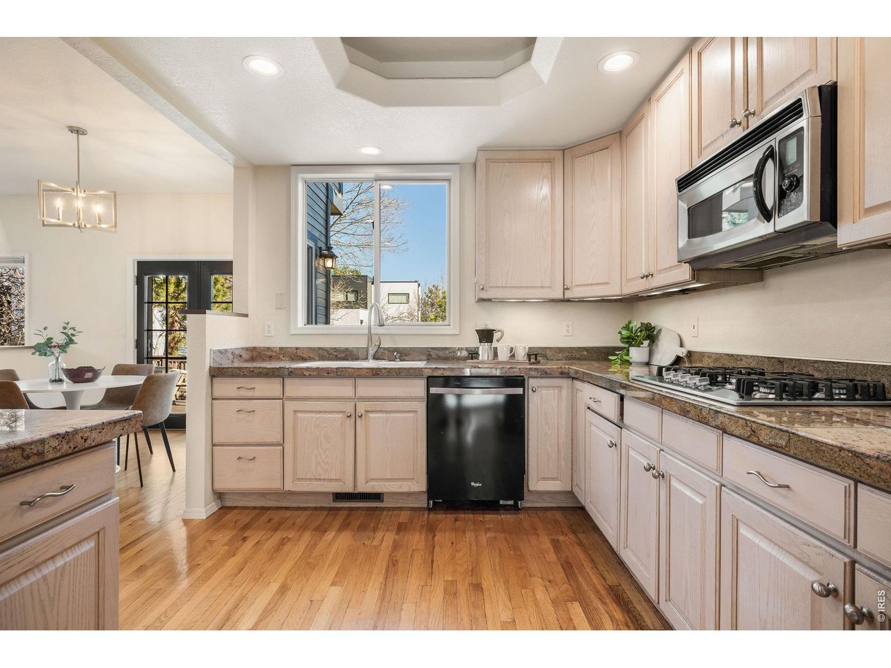 Abundant custom cabinetry, tray ceiling and windowed sink. 