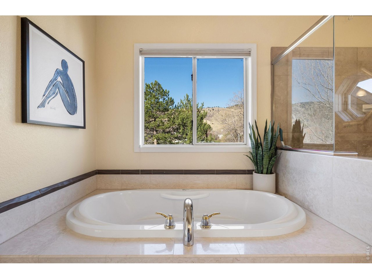 Large soaking tub framed under gorgeous views.