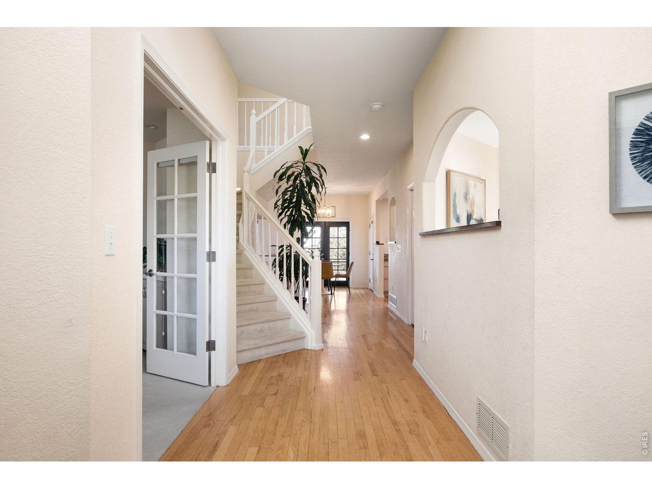 Entryway and foyer with sunken living room to the right and french doors leading to a private office with south facing light. 
