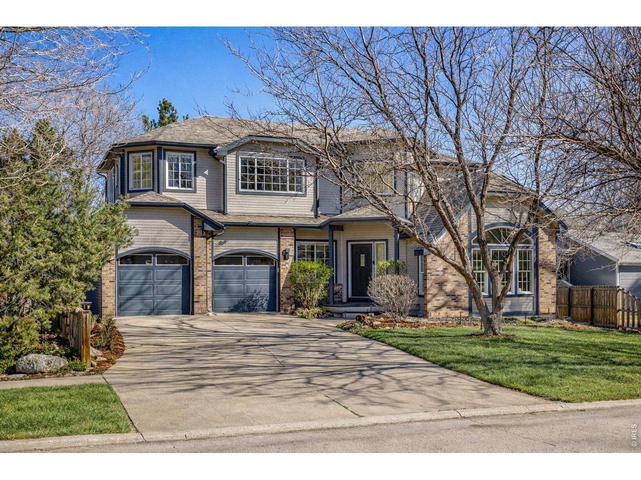 Spacious two car garage and wide driveway for ease of parking and hosting. (Image enhanced with Ai to show greener grass)