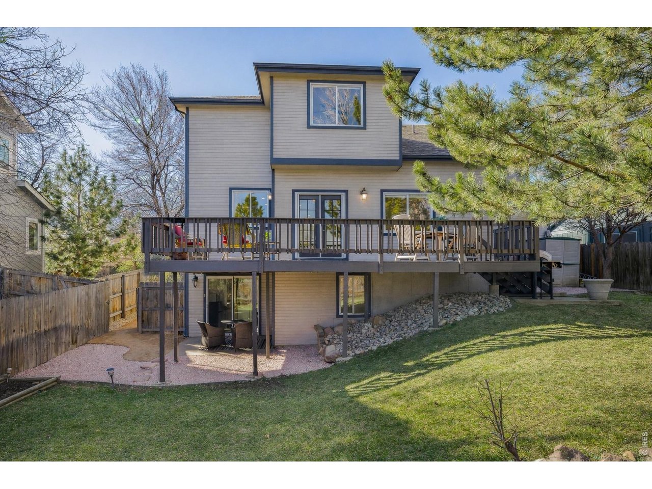 Backyard wraparound porch and lower level private patio for guests. (Image enhanced with Ai to show greener grass)