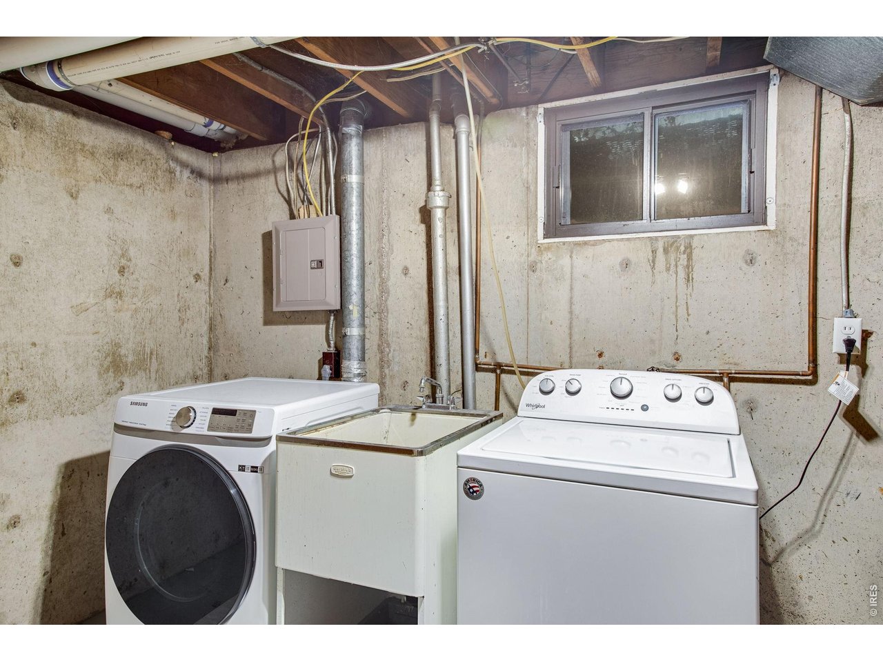 Basement: Laundry room, washer and dryer stay with a large utility sink between them.