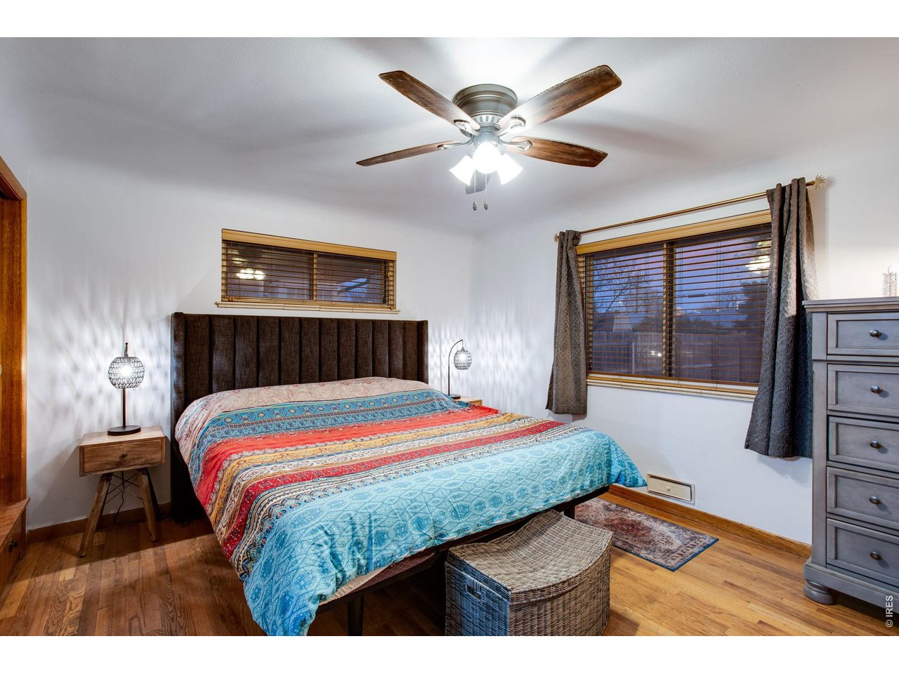 Primary: Bedroom has south facing windows and original warm wood floors.