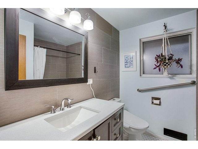 Property Photo 20 Shared Hall Bath: The full main level bath has a bidet, updated vanity and tile. There is also a useful handrail under the window.