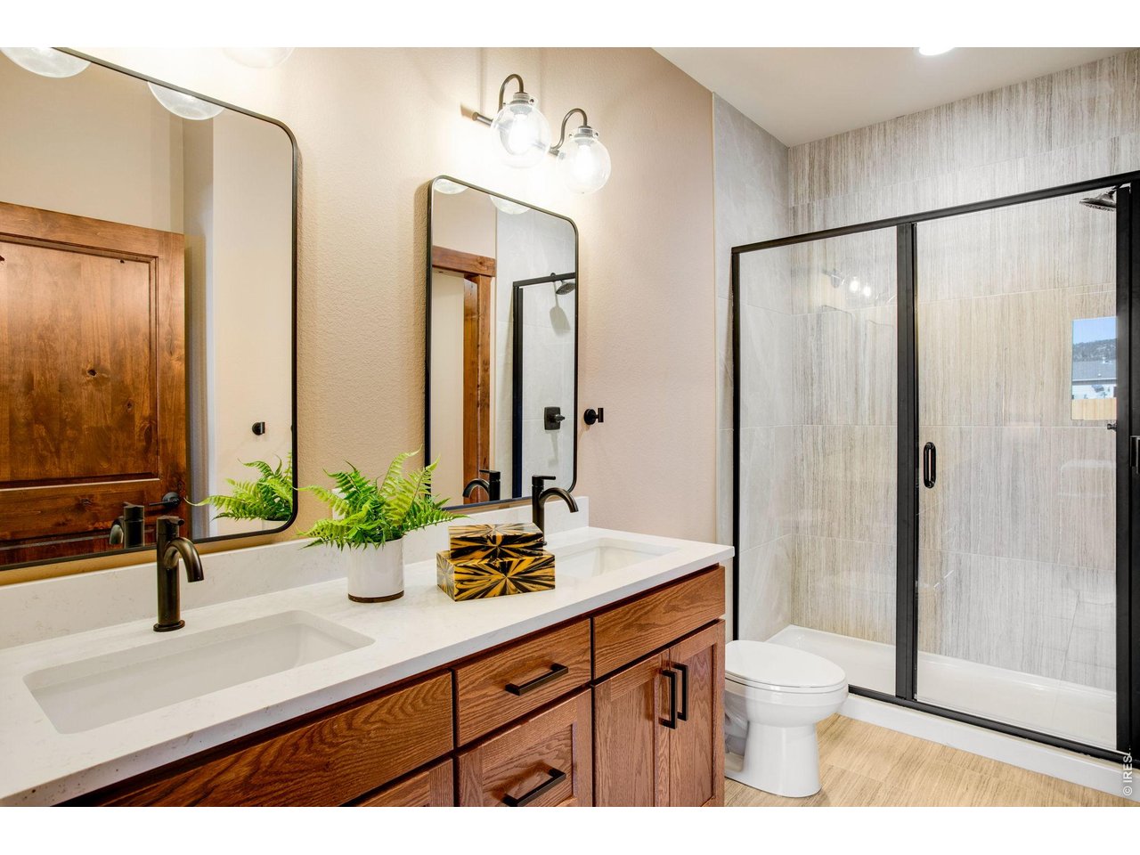 Double sinks and glass shower in primary bathroom