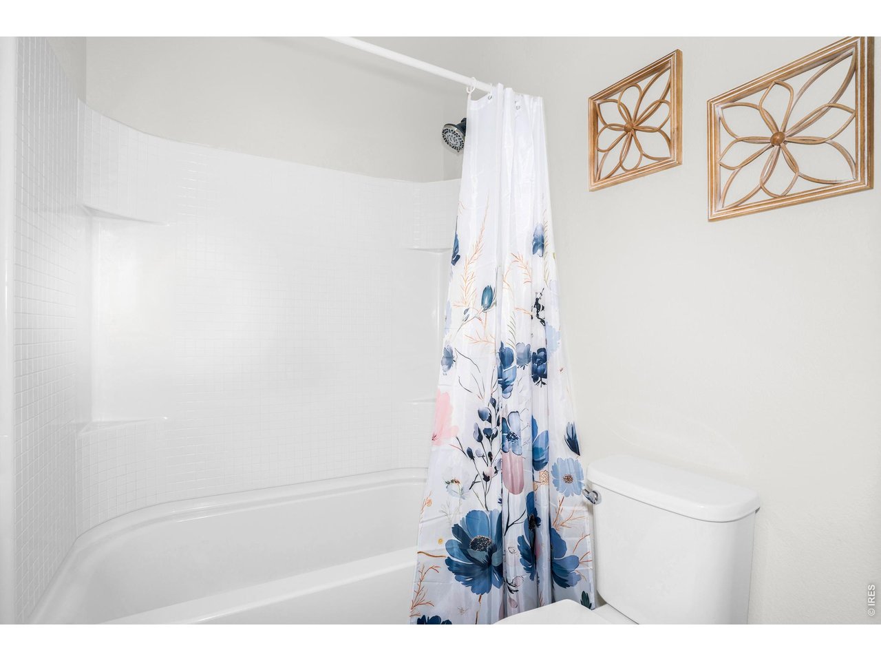 A shower/tub combo, with clean white finishes. 