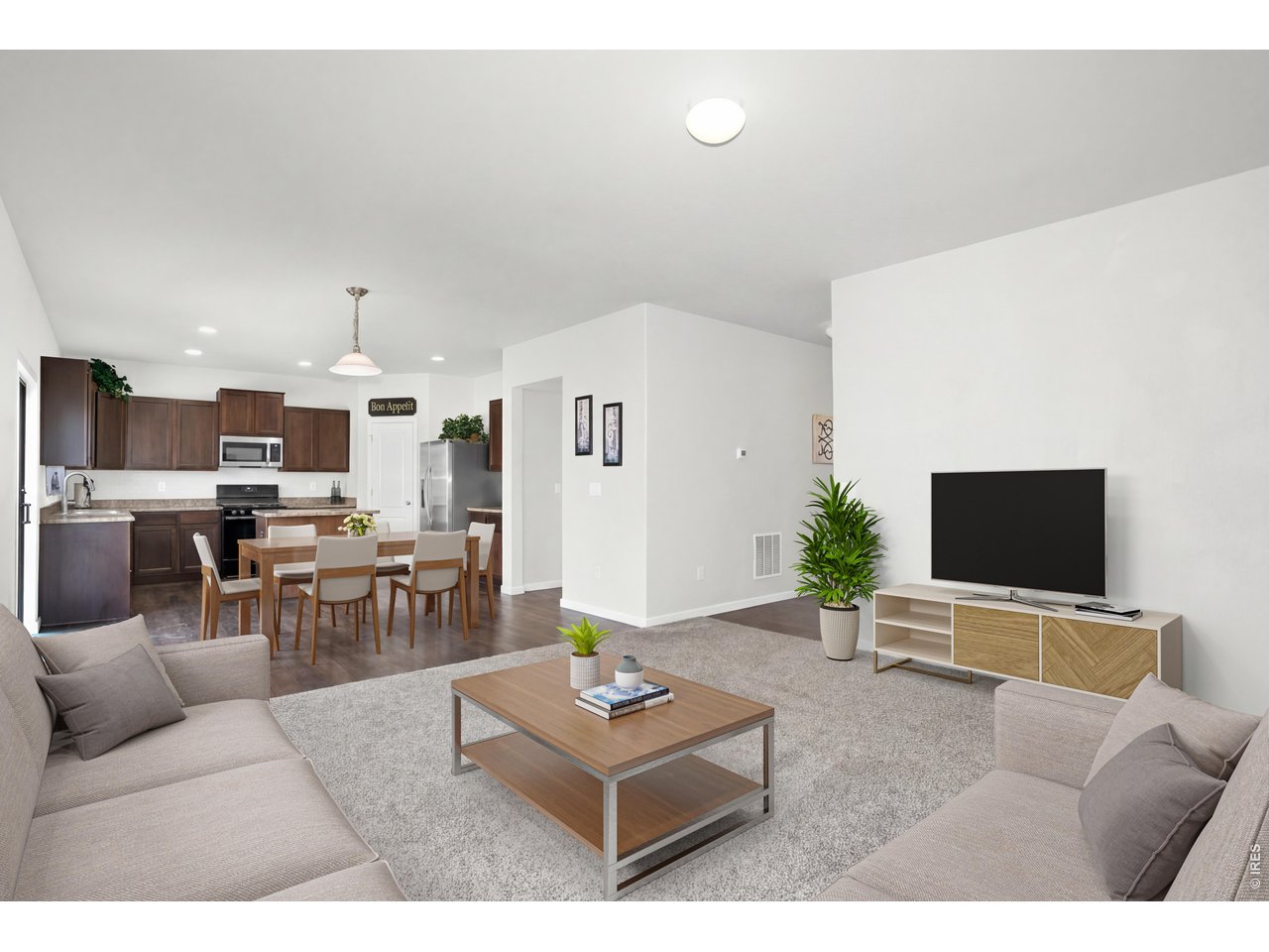 The open-concept layout seamlessly connects the living, dining, and kitchen areas, creating a cohesive space designed for both everyday living and effortless entertaining. 