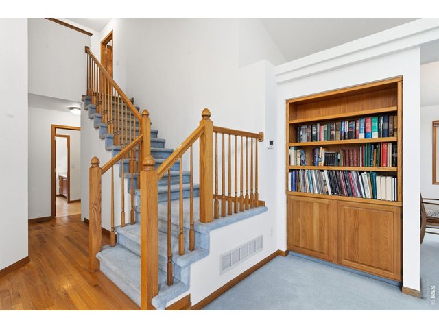 Property Photo 25 Staircase and living room with built in cabinets. 