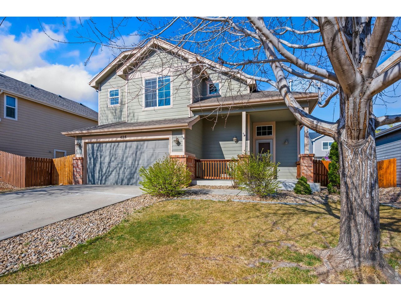 Established trees in front of home with covered porch for comfortable outdoor sitting