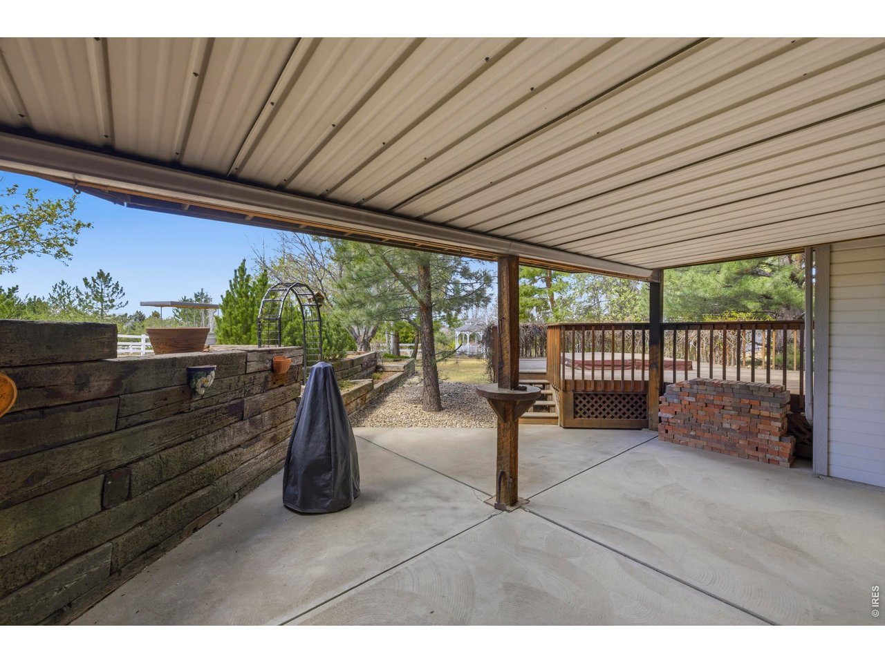 Shaded Patio with Tiered Flower Beds and Covered Roof 