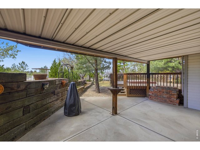 Property Photo 36 Shaded Patio with Tiered Flower Beds and Covered Roof 